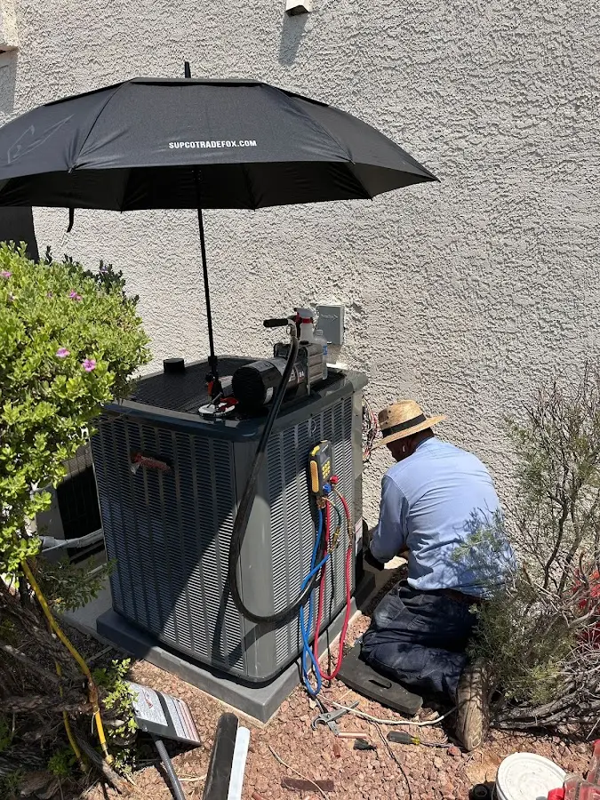 HVAC technician performing outdoor AC maintenance in Austintown