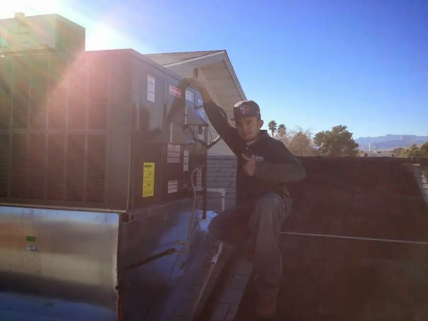 HVAC technician performing AC Tune-Up on a rooftop unit in Austintown